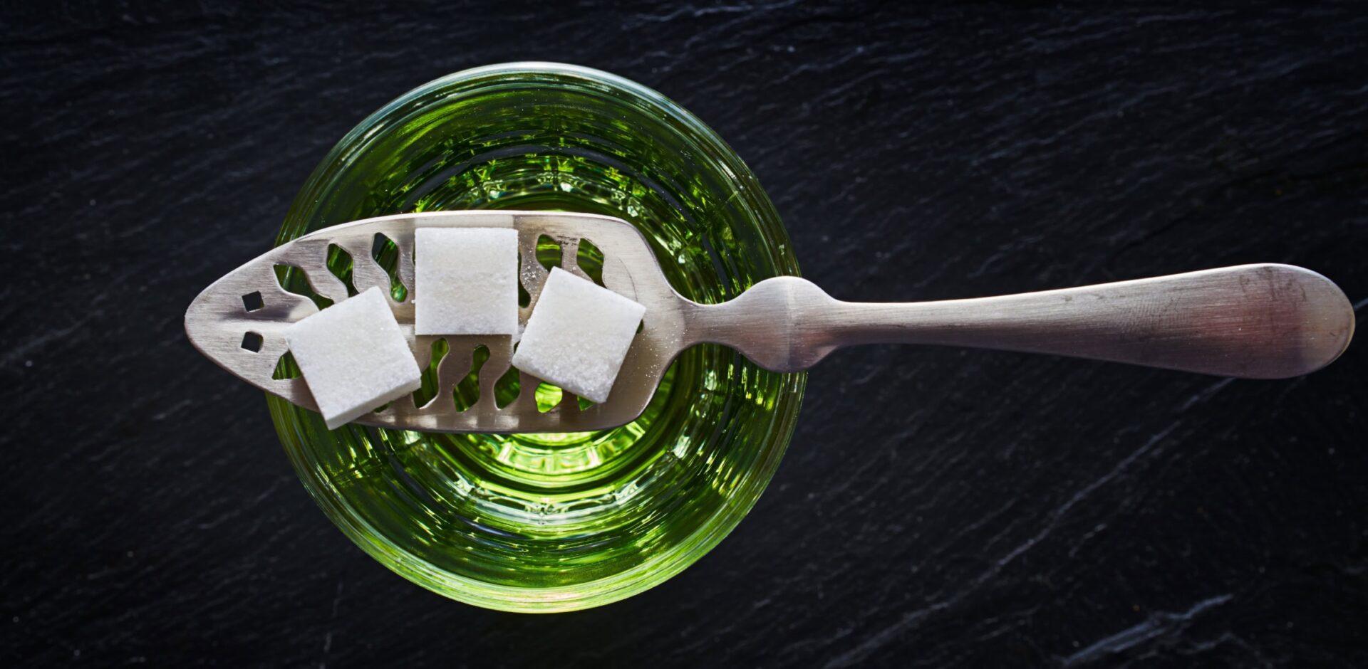 absinthe with sugar cubes and spoon flat lay composition. By Joshua Resnick - AdobeStock